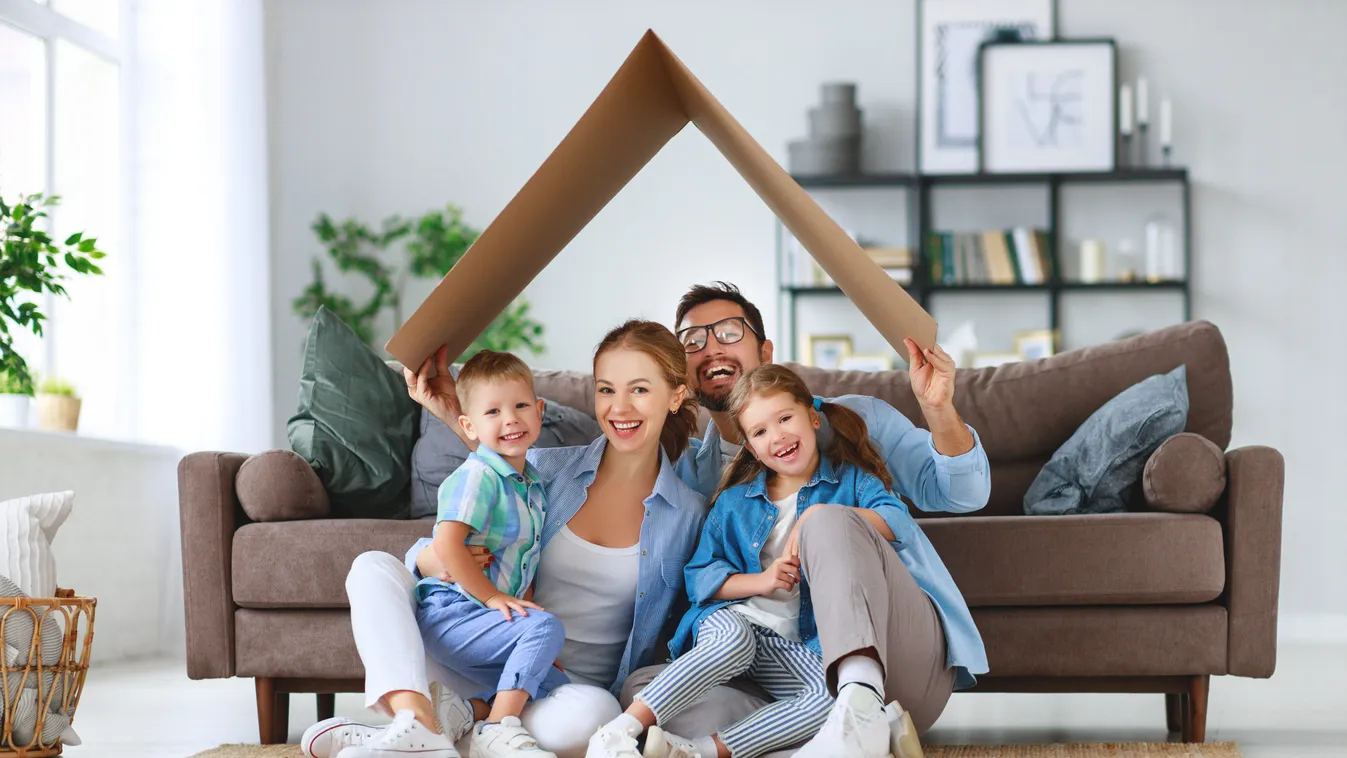 concept of housing and relocation. happy family mother father and kids with roof at home