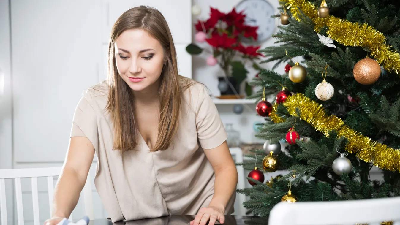 Portrait,Of,Attractive,Young,Woman,Wiping,Table,Before,Christmas,Celebration