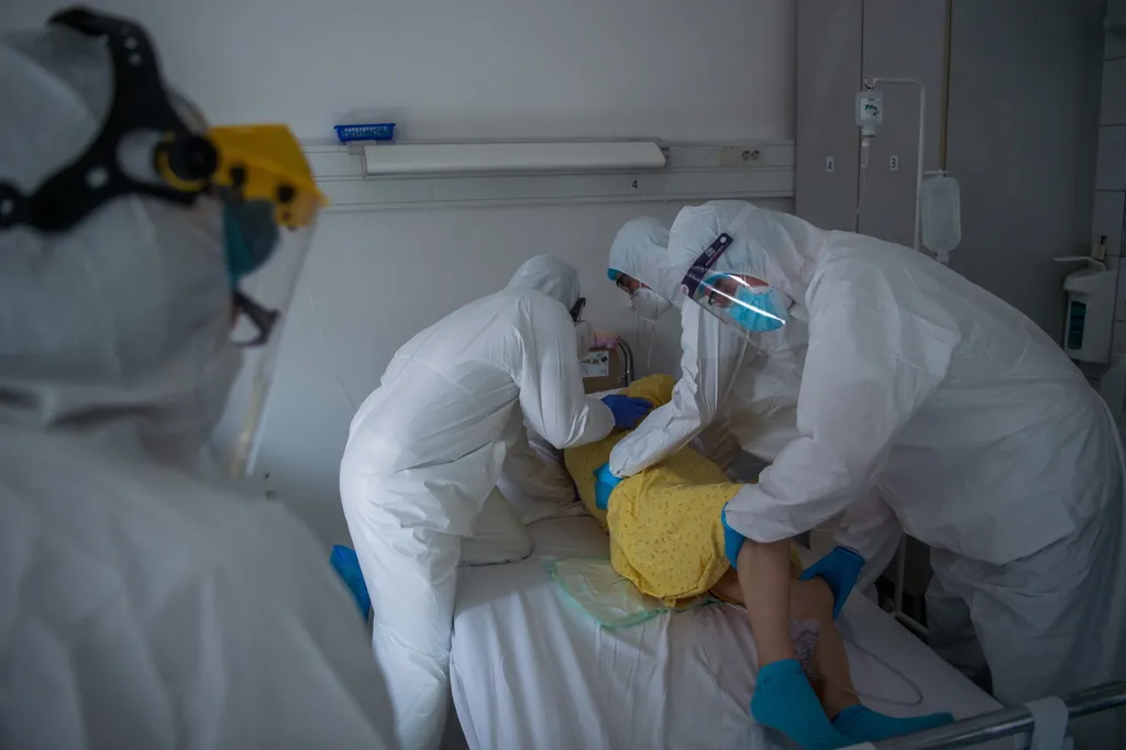 Védõfelszerelést viselõ orvosok hasra fordítanak egy beteget a fõvárosi Honvédkórház koronavírussal fertõzött betegek fogadására kialakított osztályán