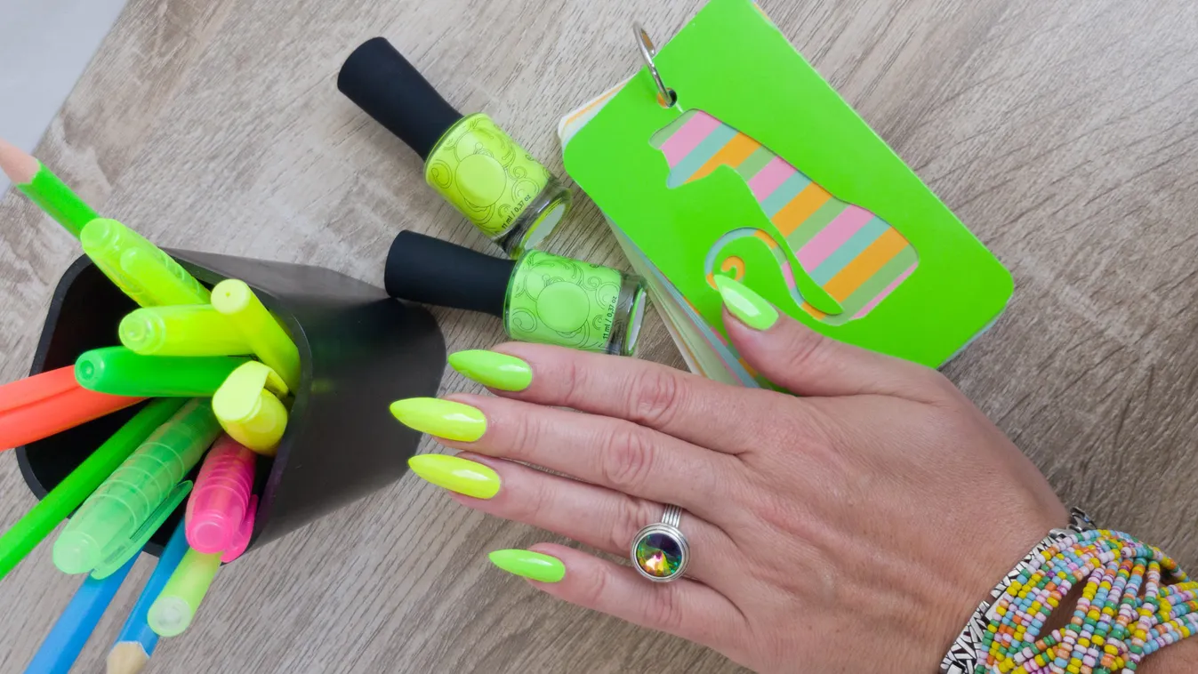 Female,Hand,With,Long,Nails,And,A,Bottle,Of,Bright