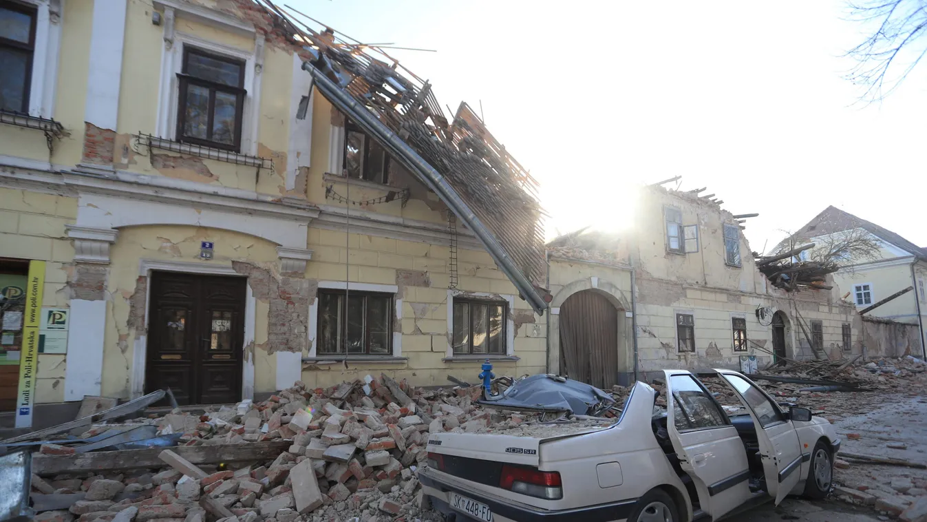 Destroyed houses and a car are seen on a street after an earthquake in Petrinja