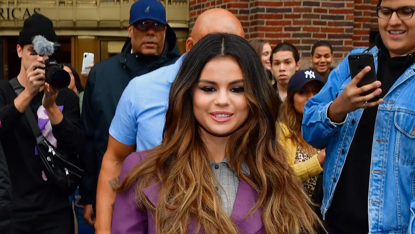 Selena Gomez rocks purple jacket over gray sweater for iHeart promo in NYC