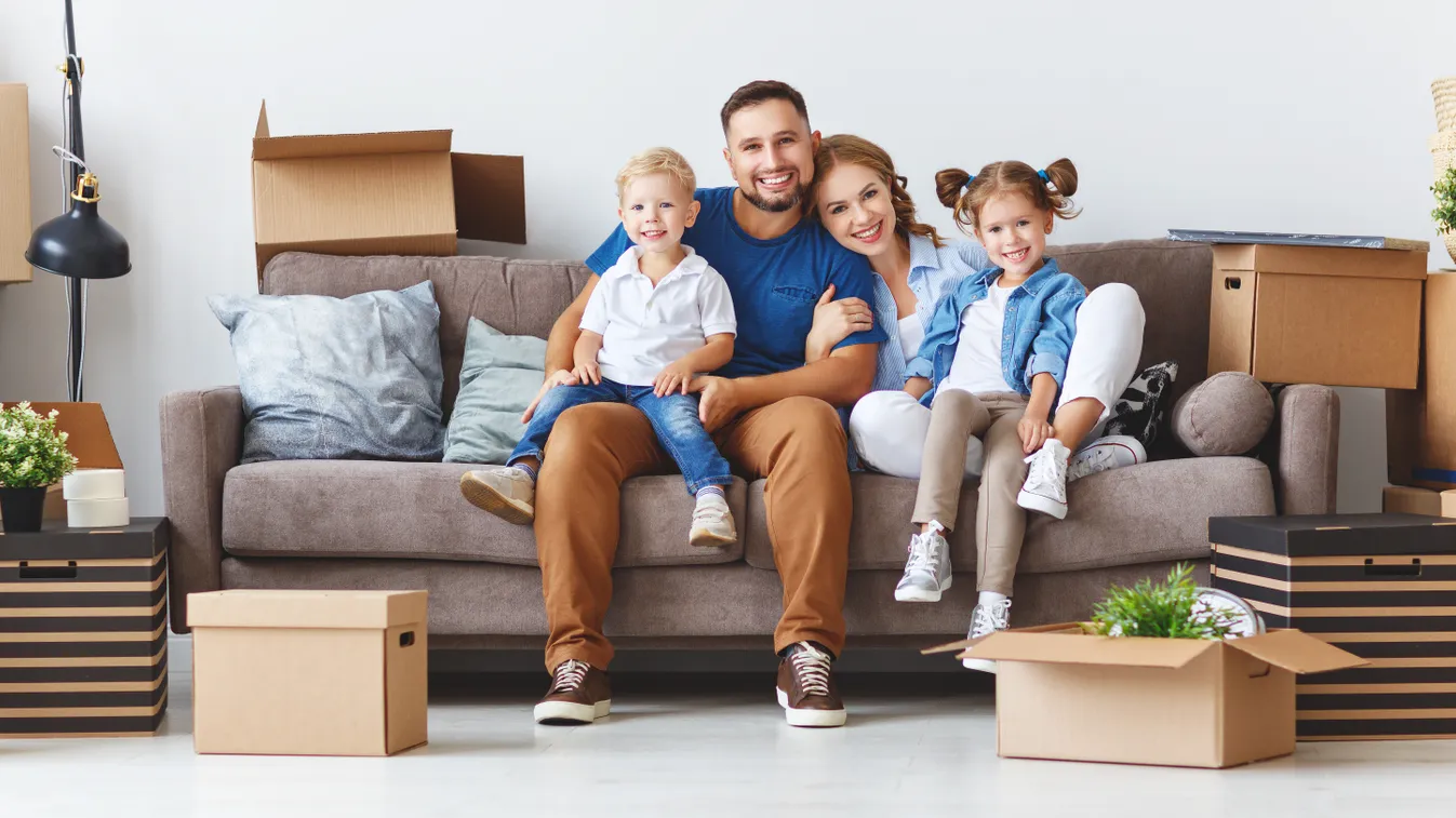 happy family mother father and children move to new apartment and unpack boxes