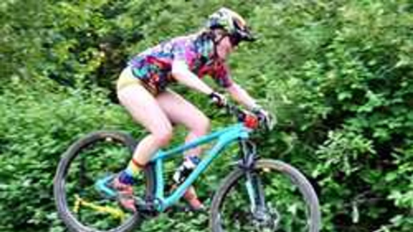 Pucéran biciklizett egy erdei úton a vadóc sportolólány