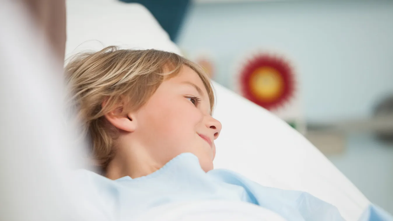 Child lying in hospital bed smiling