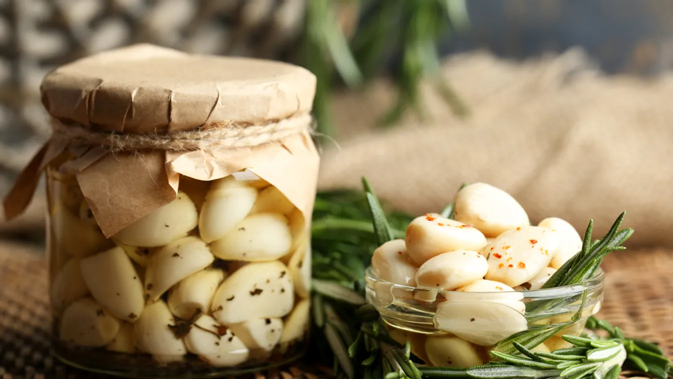 Canned,Garlic,In,Glass,Jar,And,Wicker,Mat,And,Rosemary