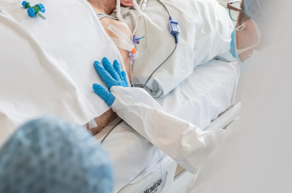 Lélegeztetett beteg karját simogatja családtagja Nyíregyházán, a Jósa András Oktatókórház koronavírussal fertõzött betegek fogadására kialakított intenzív osztályán