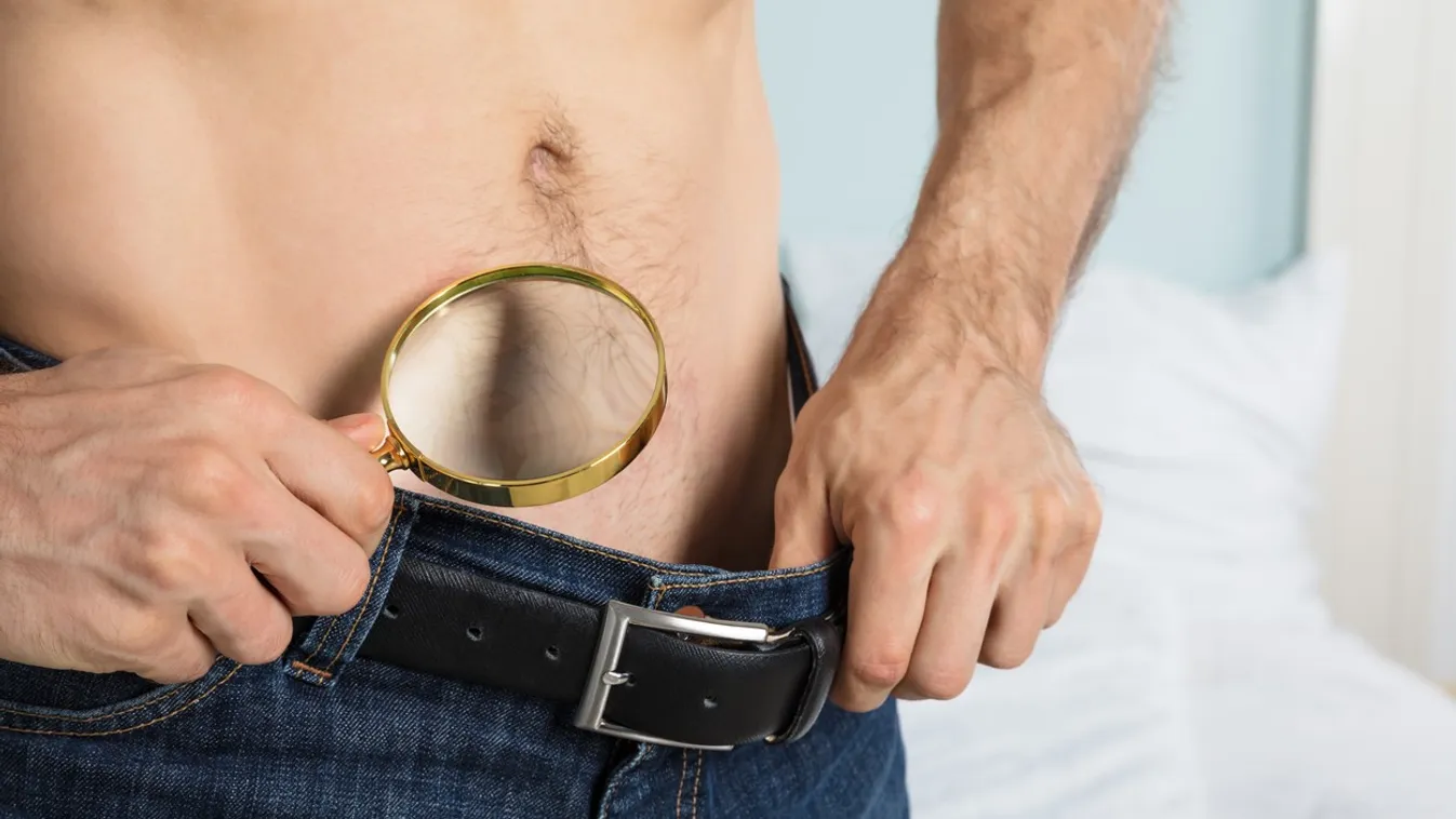 Person Looking Into Jeans Using Magnifying Glass