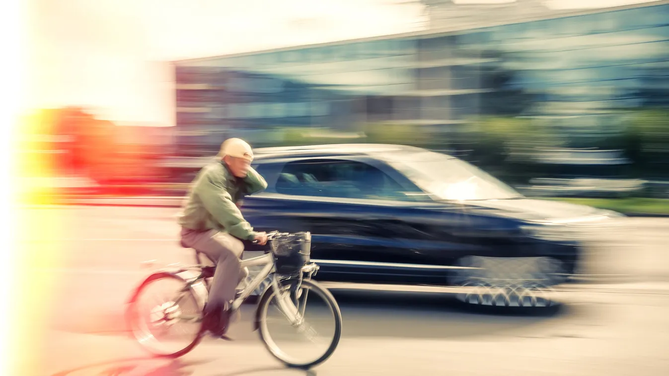 Cyclist,And,A,Car,On,The,Street.,People,Hurrying,About