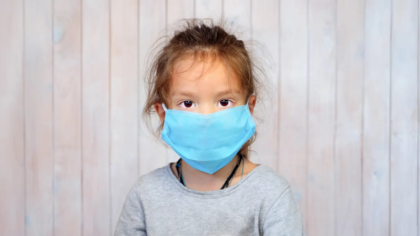 Baby Girl in Medical Mask. Children and Coronavirus. Five Years Old Girl Wearing Mask Looking at Camera. Portrait of Beautiful Girl in Medical Mask. Adult Child in a Mask. Serious Face of a Small Kid