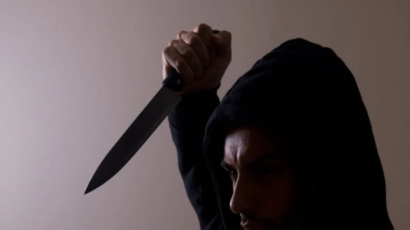 Hooded man stabbing with knife