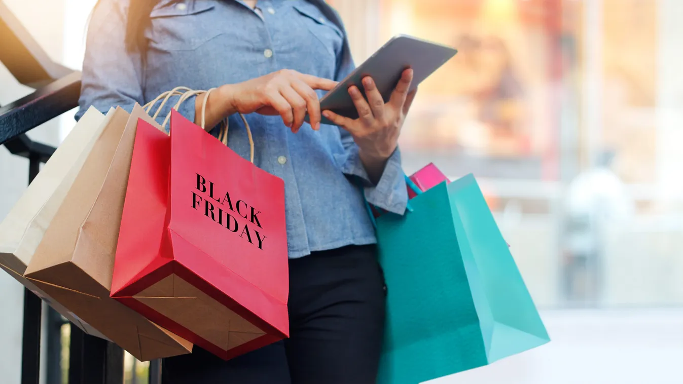 Woman,Using,Tablet,And,Holding,Black,Friday,Shopping,Bag,While