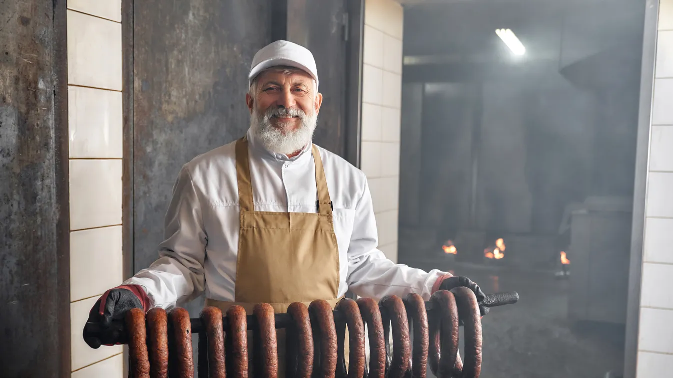 Smoked,Sassages,Hanging,In,Row.,Handsome,Smoker,Standing,In,Smokehouse