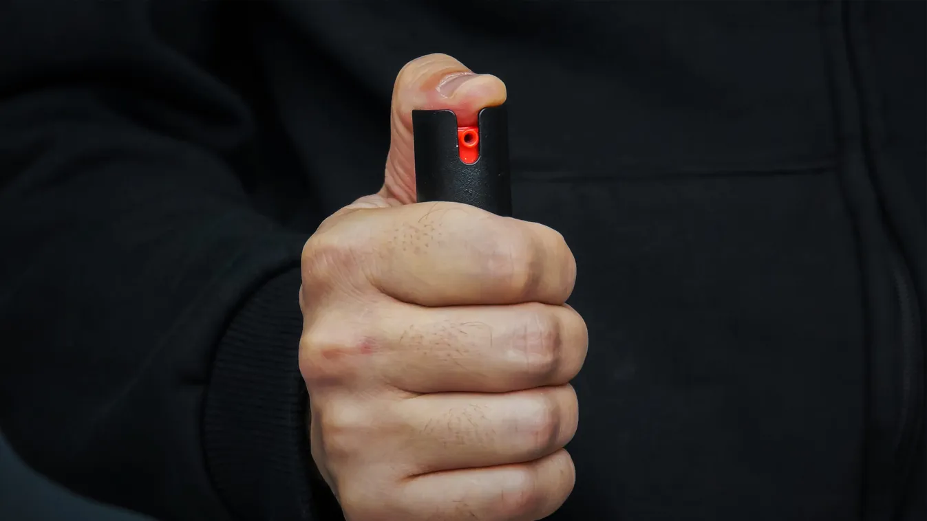 Hand with bottle of pepper spray.