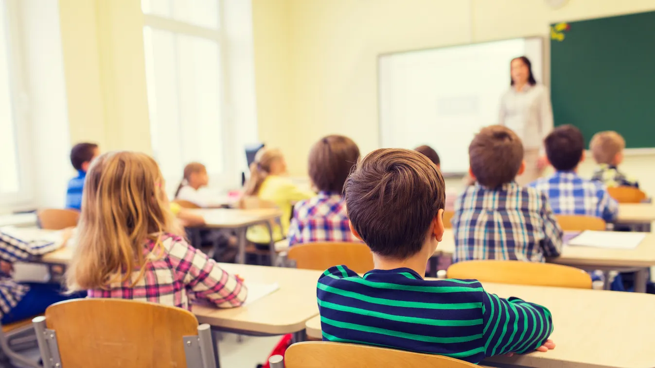 group of school kids and teacher in classroom