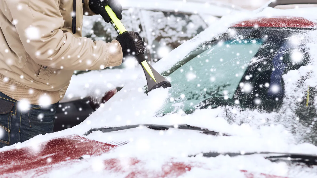 closeup of man cleaning snow from car