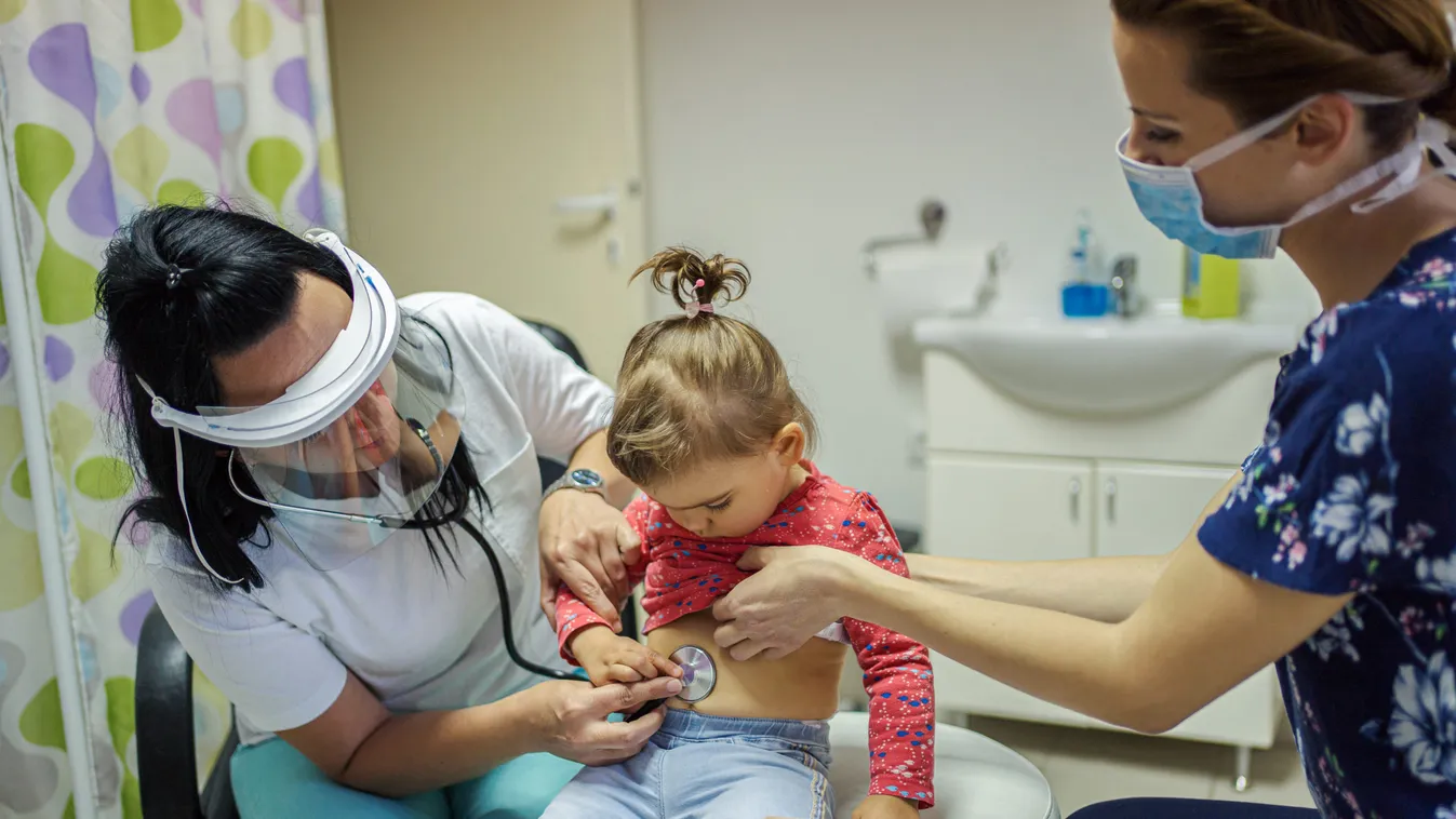 Mother with child at doctor during virus pandemic.