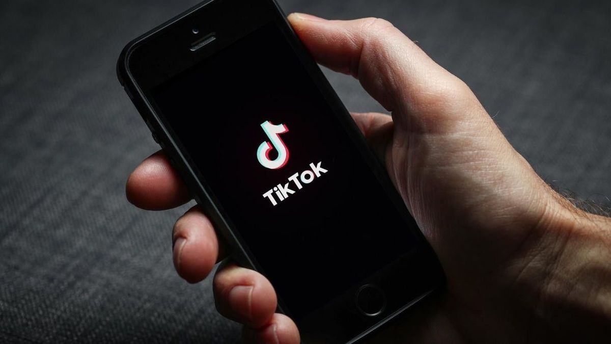 A man using the TikTok app on his mobile phone