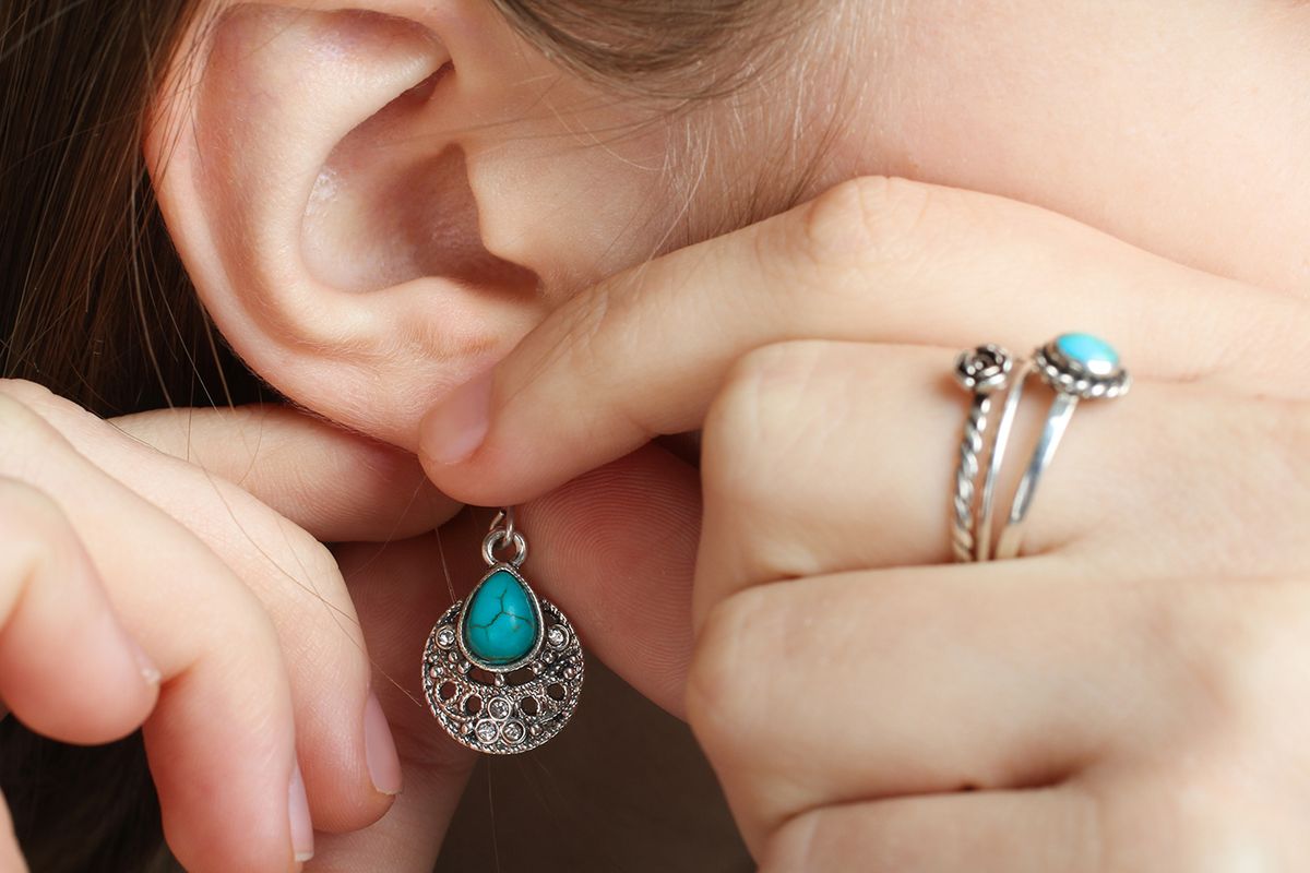 Girl,Puts,On,Earring,With,Turquoise,Stone,On,Her,Ear,