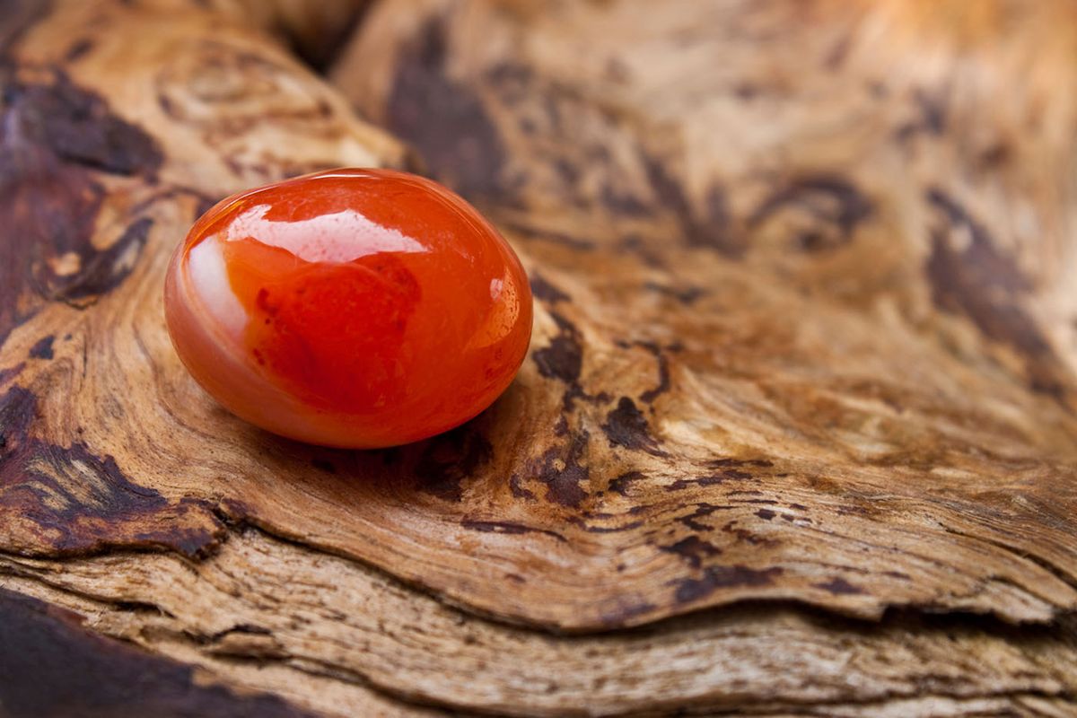 Red,Carnelian,Against,Wooden,Background