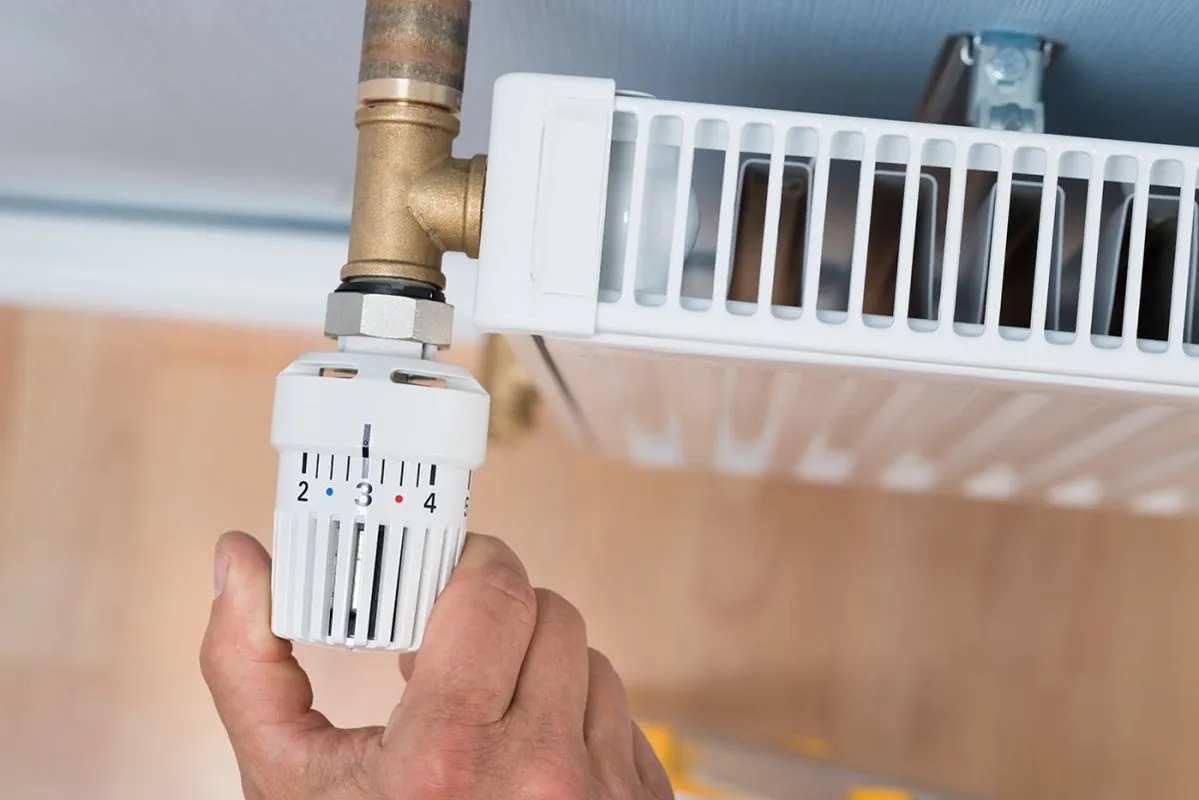 Close-up,Of,A,Person's,Hand,Adjusting,Temperature,Of,Radiator,Thermostat