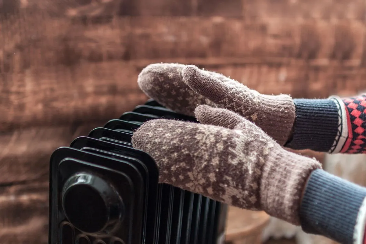 Women's,Hands,In,Christmas,,Warm,,Winter,Mittens,On,The,Heater.