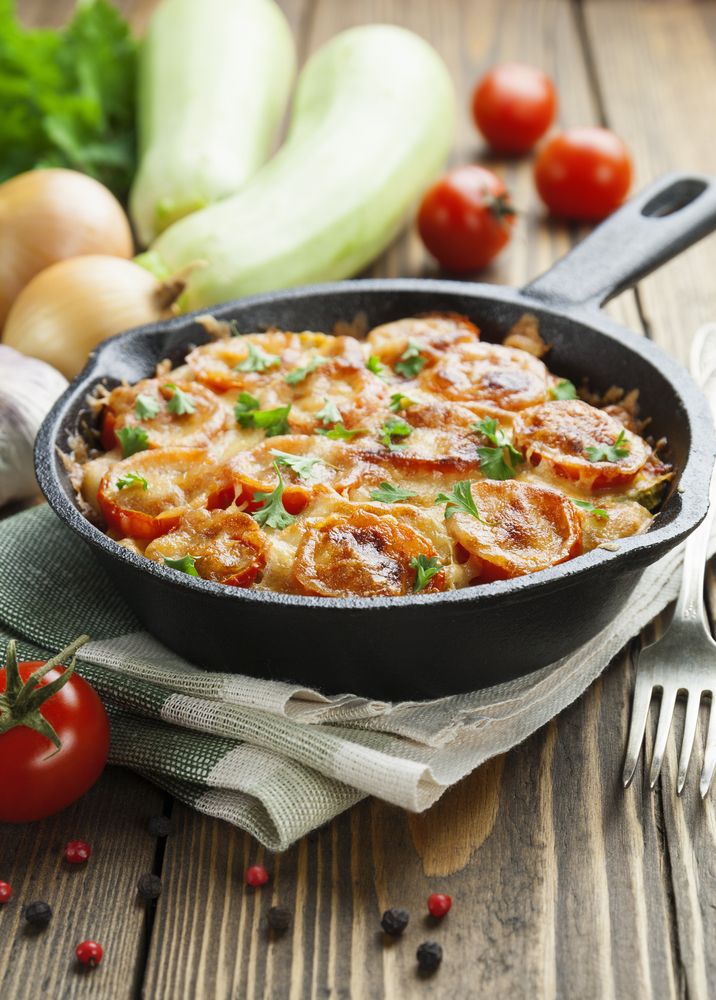 Courgettes,Baked,With,Tomato,And,Cheese,On,The,Wooden,Table