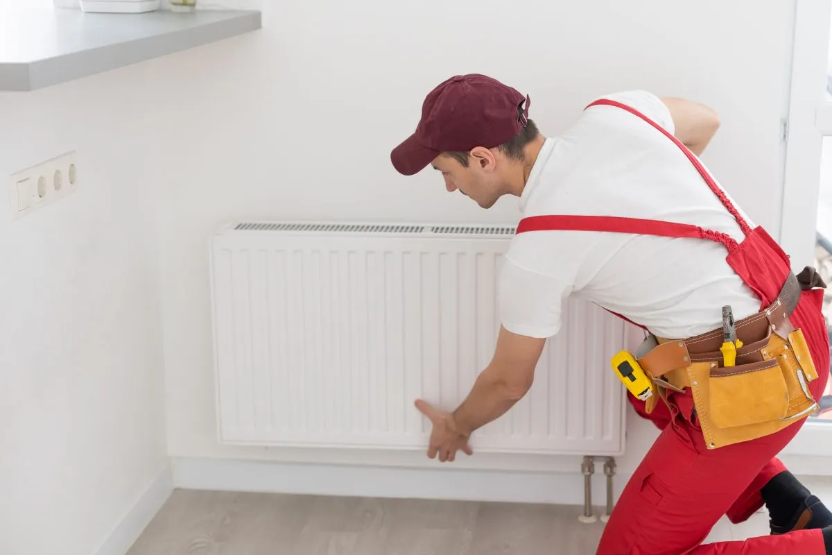Plumber,Man,Is,Blocking,Repairs,Radiators,Of,Heating,Battery,In