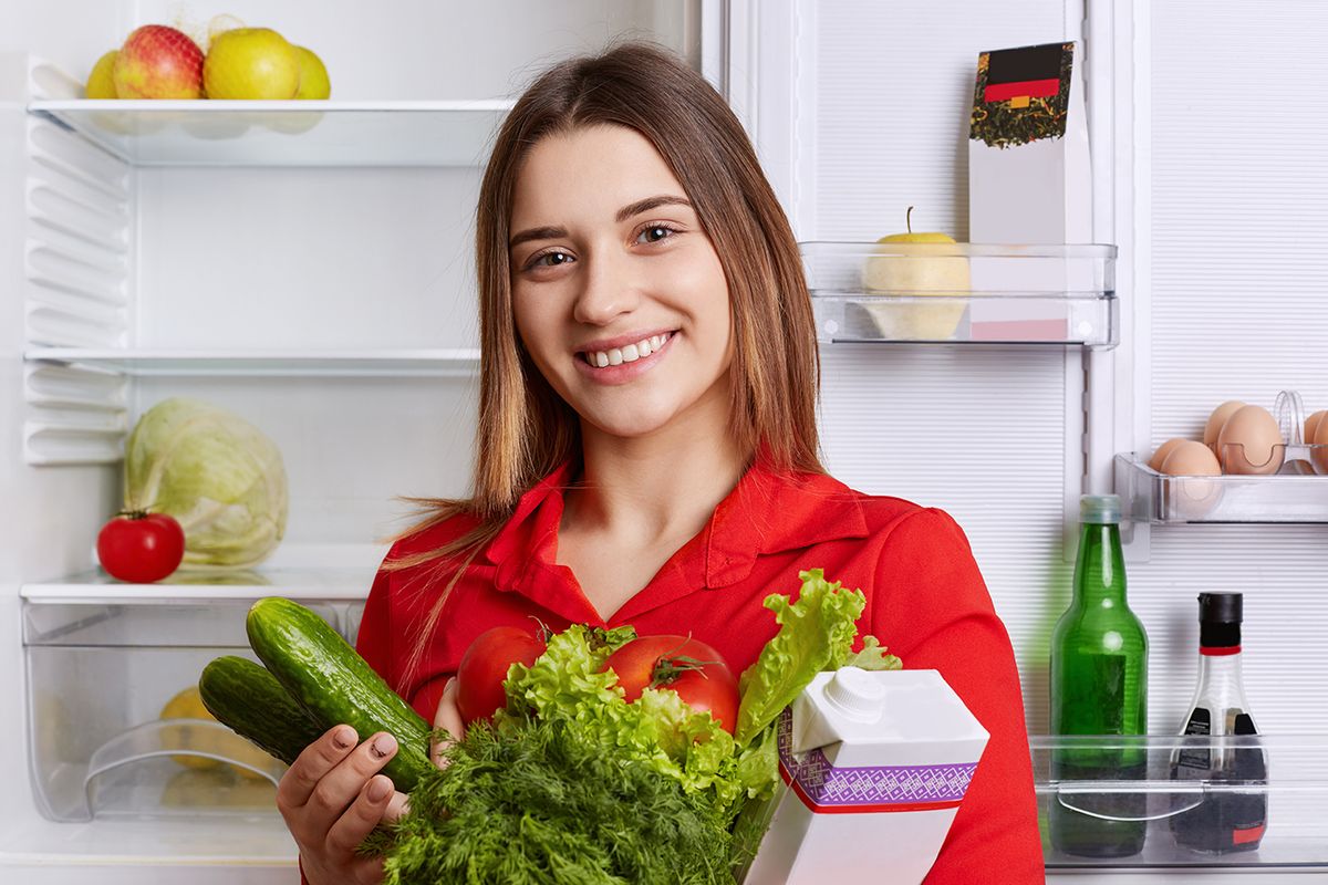 Satisfied,Woman,Holds,Fresh,Vegetables,And,Milk,,Going,To,Put