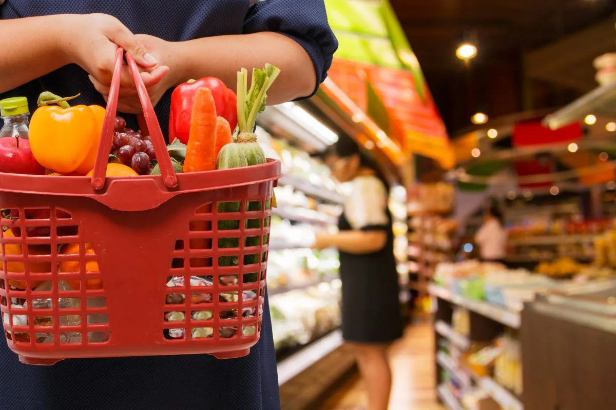 Woman,Holding,Shopping,Basket,In,Supermarket