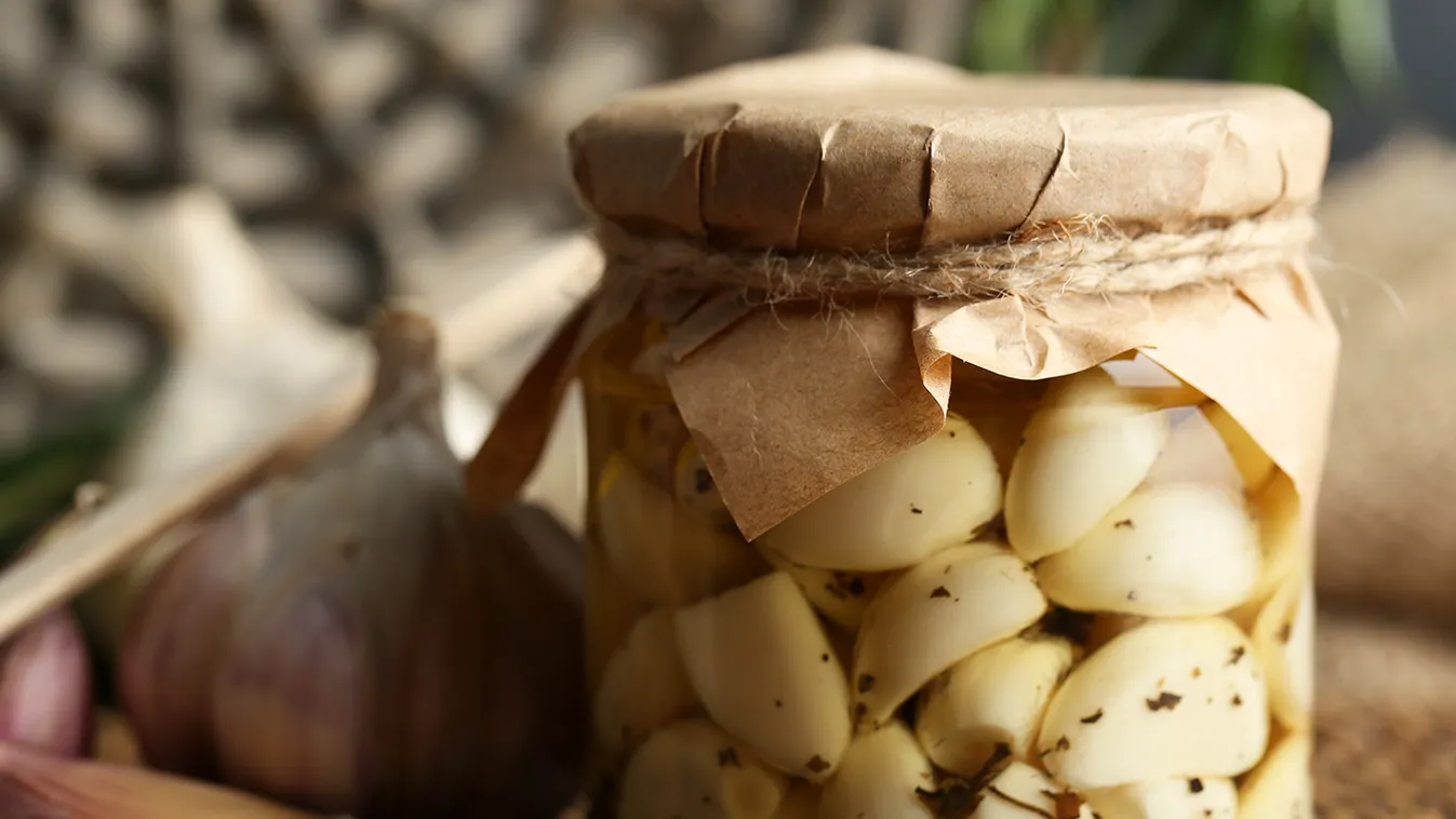 Canned,Garlic,In,Glass,Jar,And,Wicker,Mat,And,Rosemary