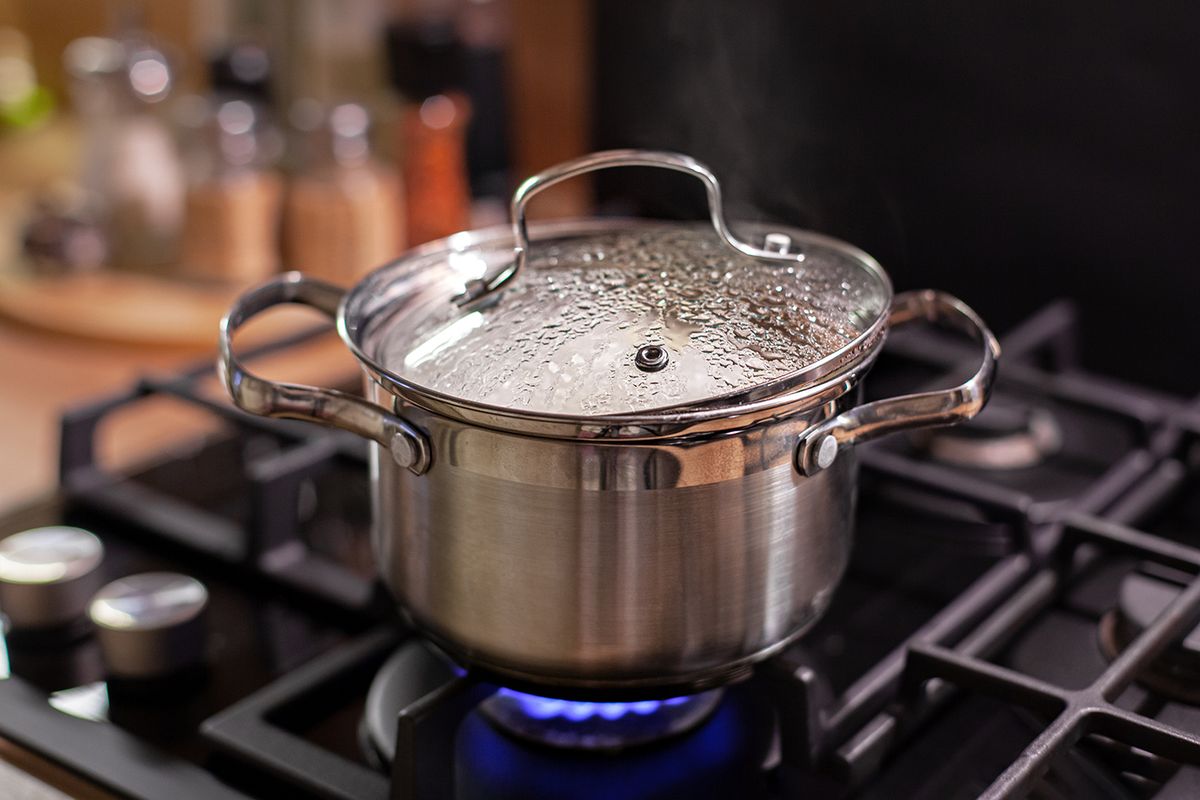 Steel,Pan,Stands,On,A,Gas,Stove,,Steam,From,Under