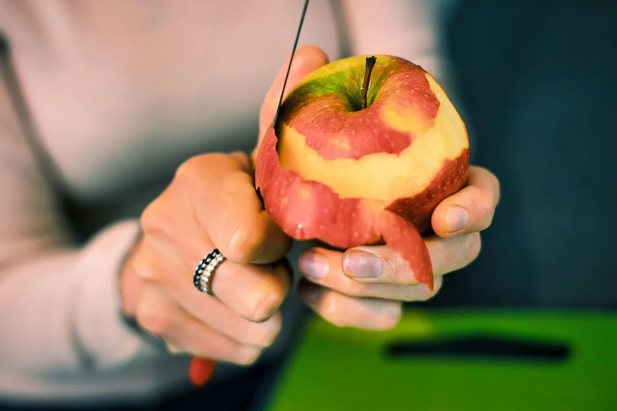 Close-up,Of,Hands,Peeling,An,Apple.,Woman's,Hands,Removes,The