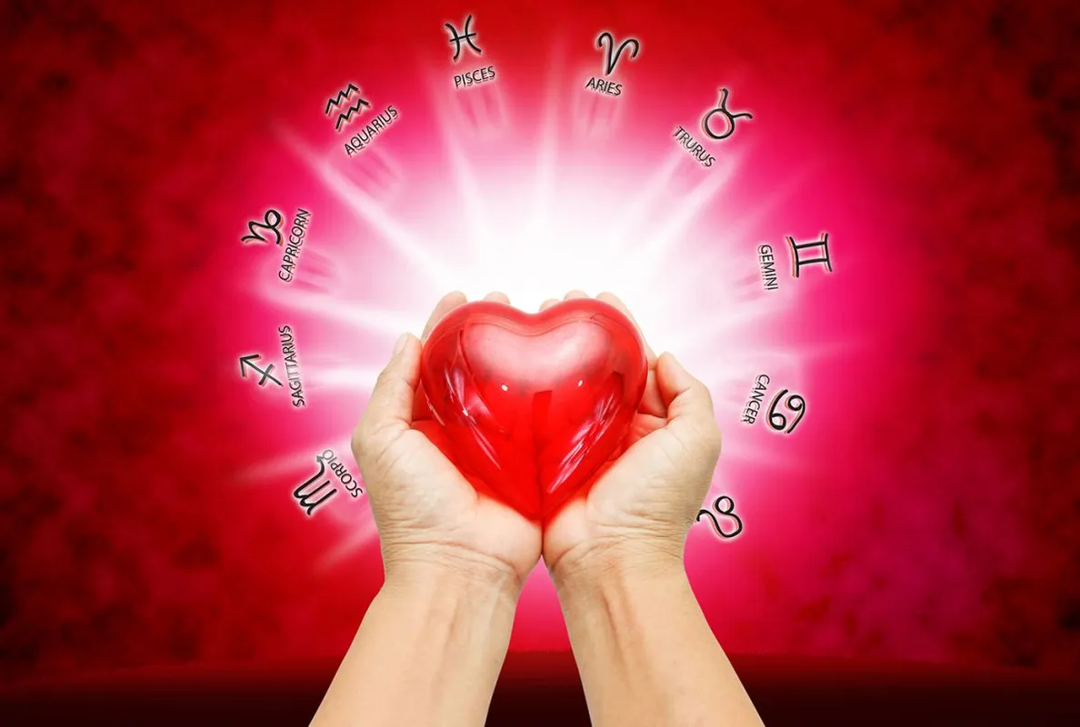 Hand,Holding,Red,Heart,On,Zodiac,Background,.
