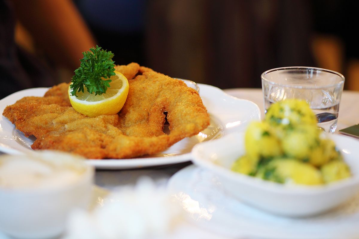 Wiener,Schnitzel,On,Table,In,Restaurant,With,Baked,Potatoes.