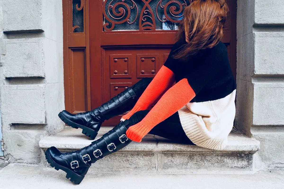 Side View Of Woman Wearing Black Leather Boot By Door