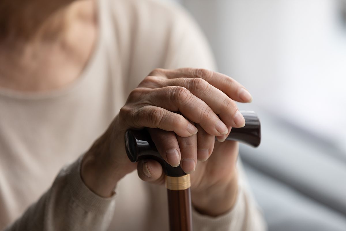 Close,Up,Focus,On,Folded,Wrinkled,Female,Hands,On,Wooden