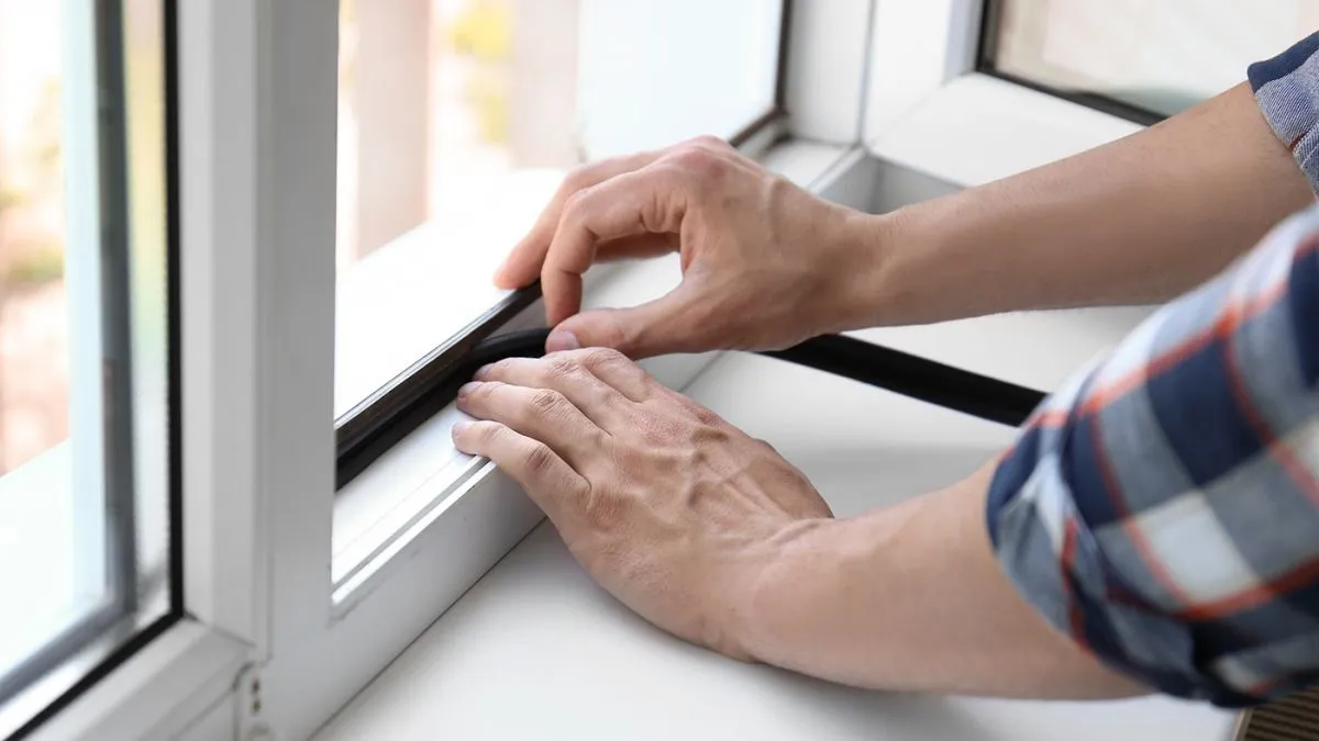 Young,Man,Putting,Sealing,Foam,Tape,On,Window,Indoors