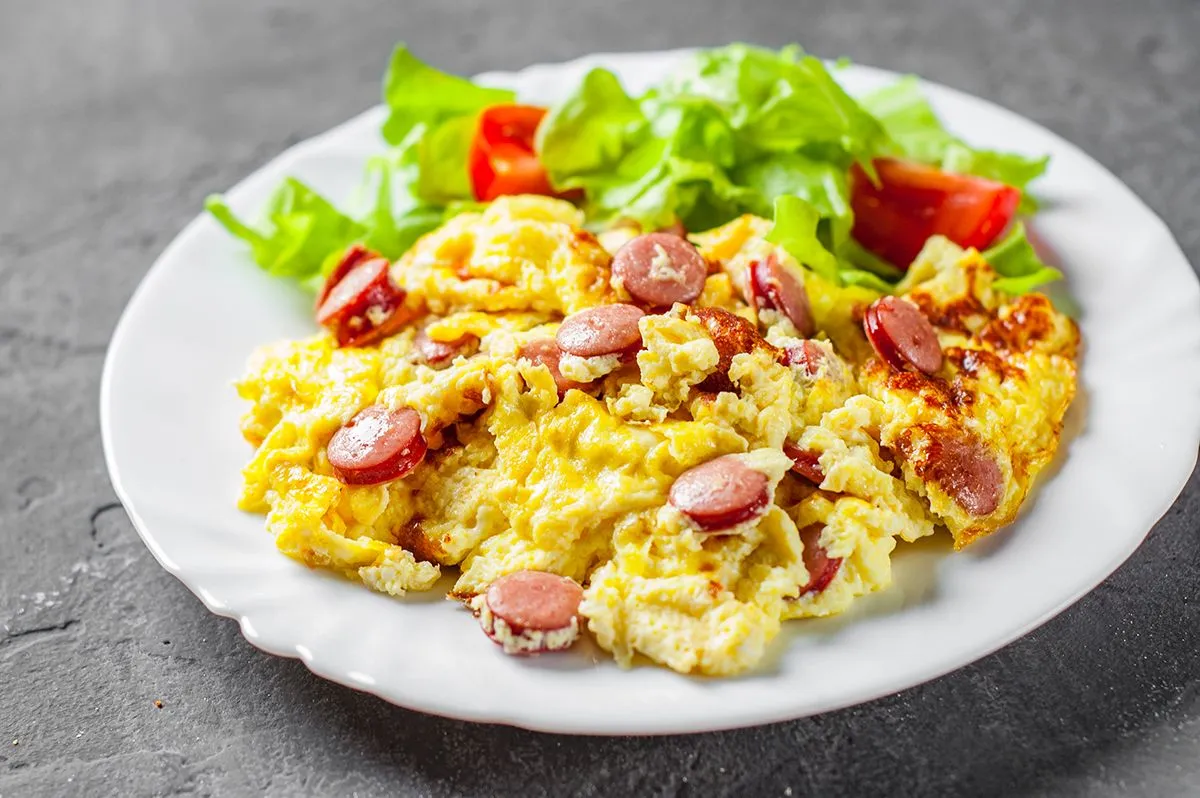 Omelet,With,Sausage,And,Vegetables,In,White,Plate,On,Dark