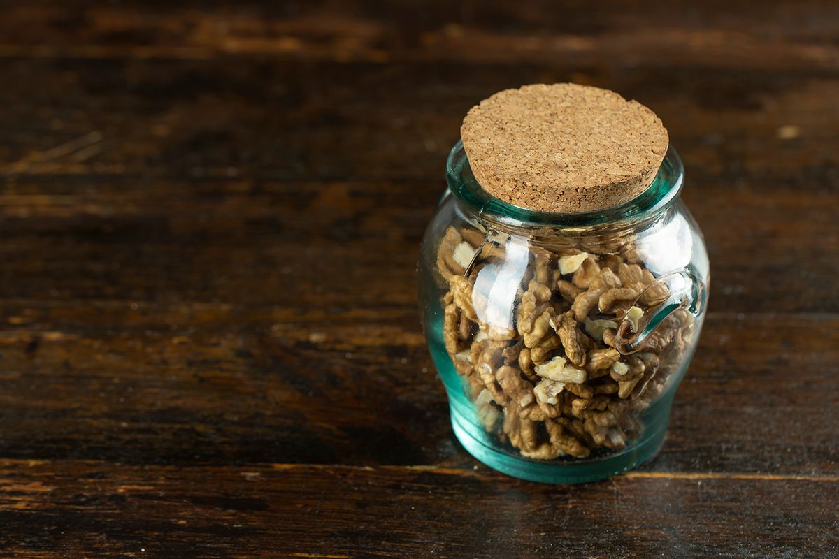 Walnut,In,In,A,Glass,Jar,On,Wooden,Background,With