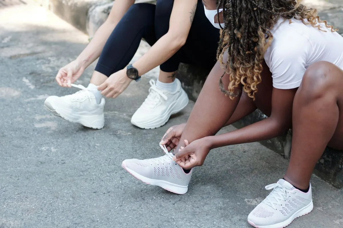 Sportswomen Tying Laces of Sneakers