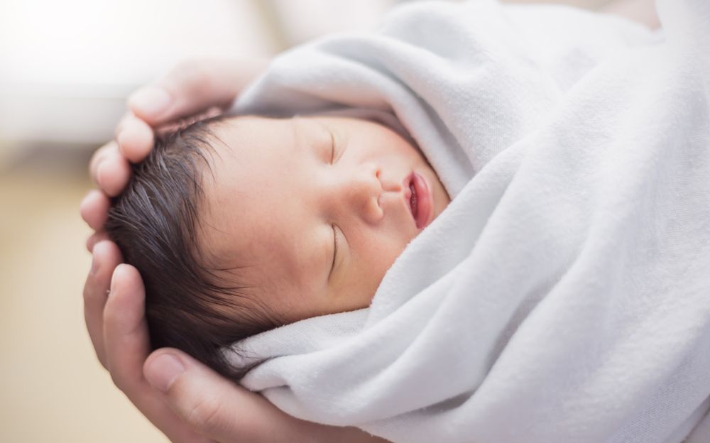 Portrait,Of,Asian,Parent,Hands,Holding,Newborn,Baby,Fingers,,Closeup