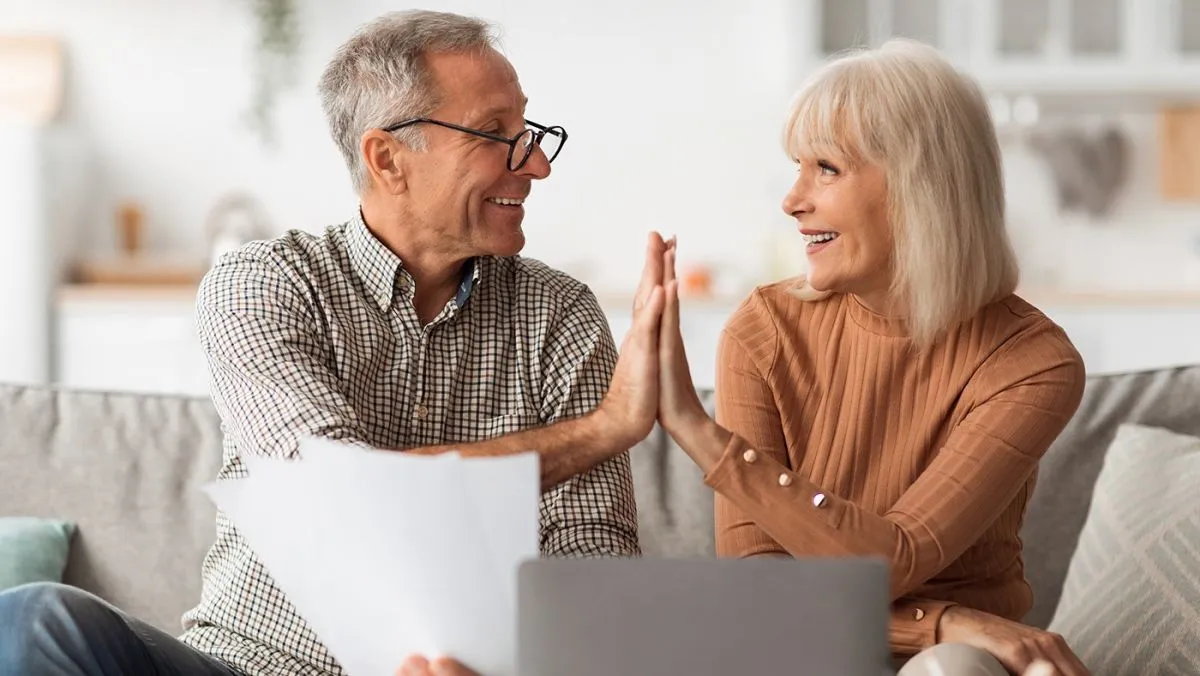 Happy,Senior,Couple,Giving,High-five,Holding,Papers,And,Documents,Sitting