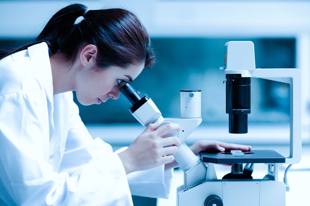 Scientist,Using,A,Microscope,In,A,Laboratory,,Testing,For,Coronavirus