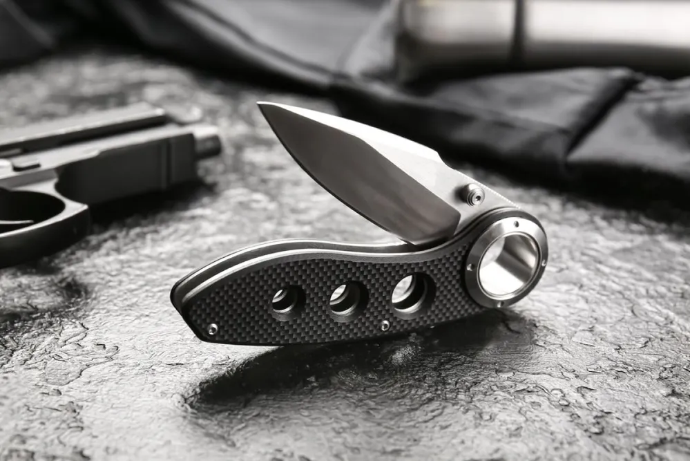 Folding,Pocket,Knife,With,Rubberized,Handle,On,Black,Textured,Background