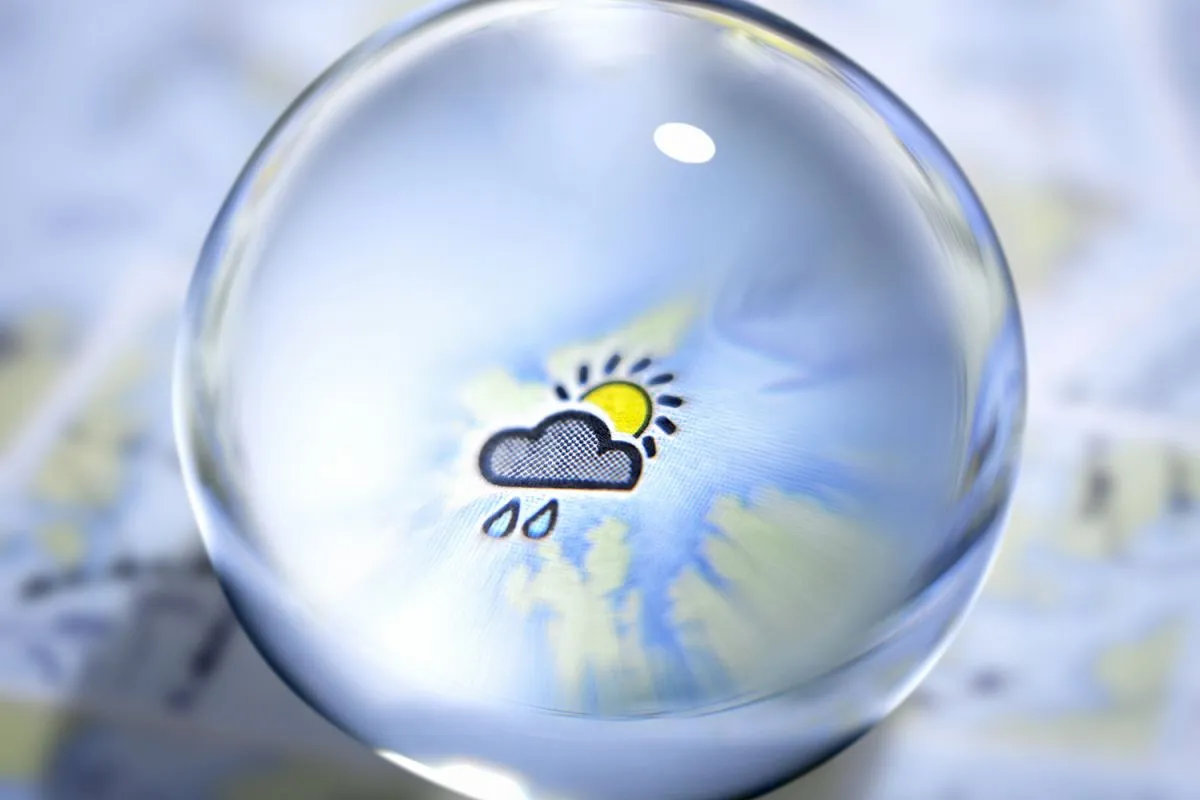Close up of glass ball with rain cloud and sun in center