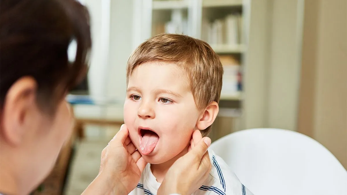 Pediatrician,Feels,The,Tonsils,In,A,Child,With,A,Sore