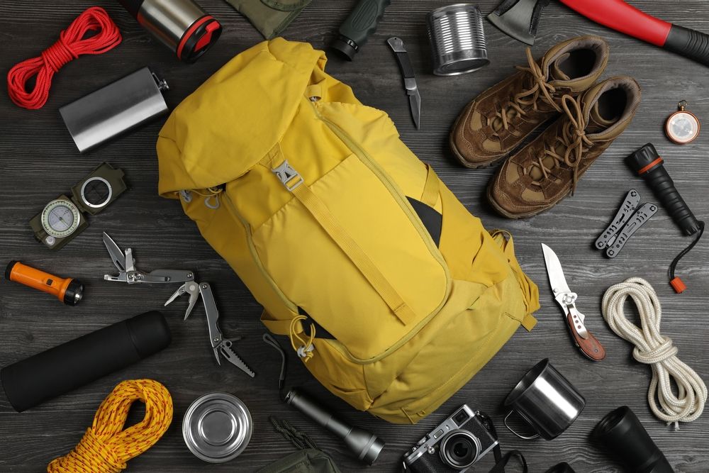 Flat,Lay,Composition,With,Different,Camping,Equipment,On,Dark,Wooden