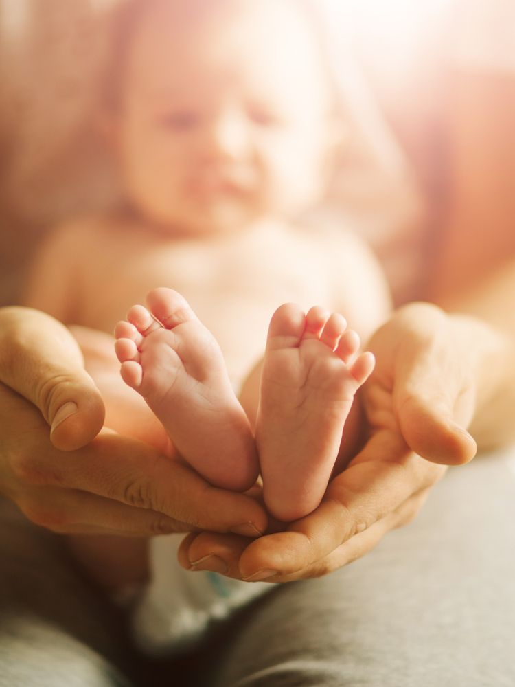 Small,Newborn,Baby,Legs,In,Mothers,Lovely,Hand,With,Soft