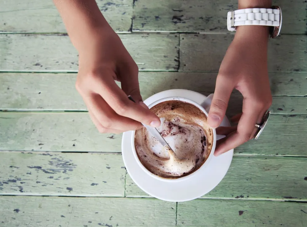 Close,Up,Image,Of,Woman,Hands,Shaking,Cappuccino,At,Shabby